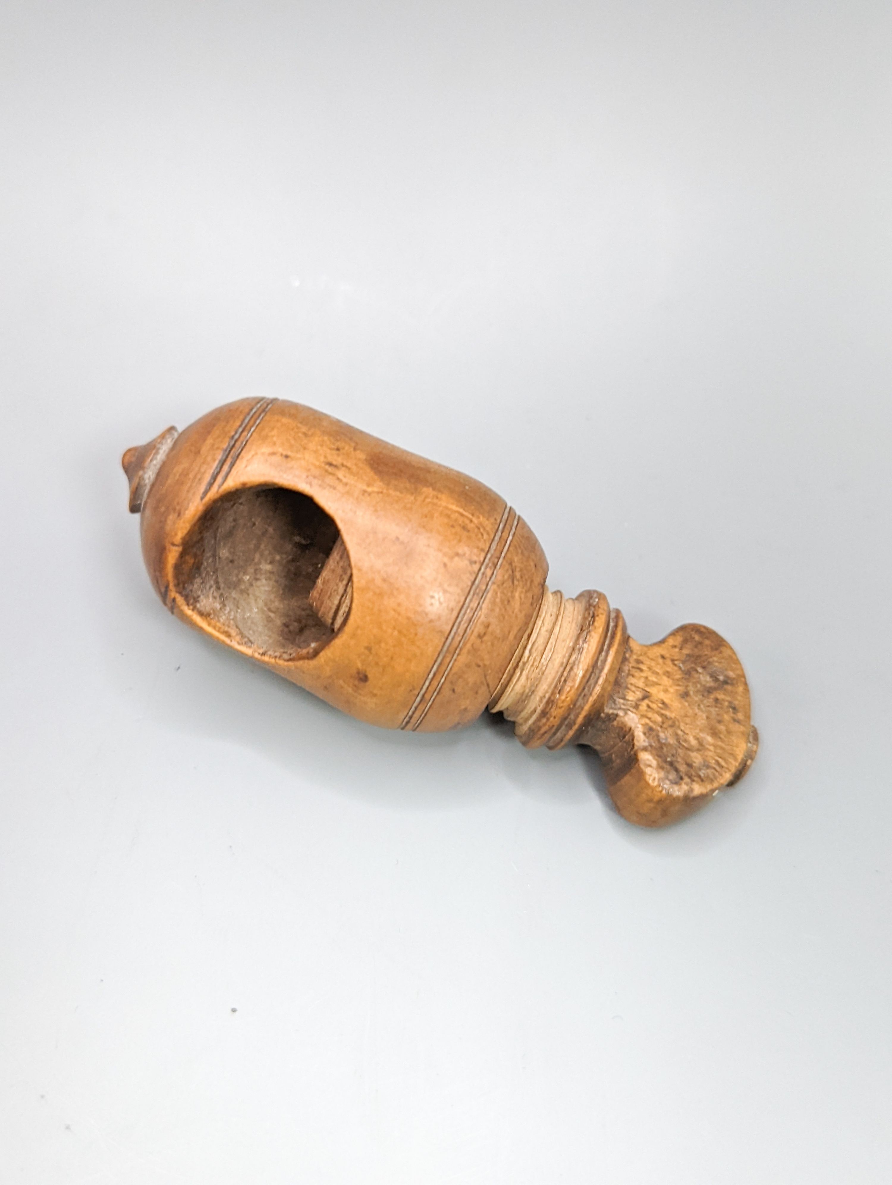 A pair of Georgian treen ‘riding boot’ nutcrackers, 14.5cm and two 19th century acorn-shaped Treen nutcrackers (3)